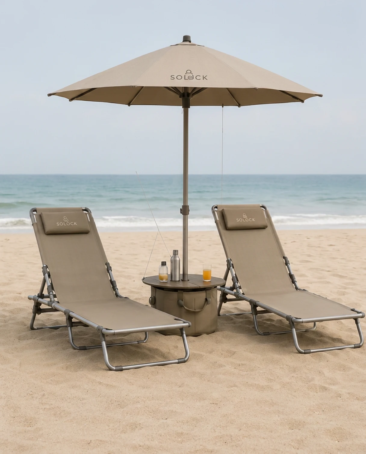 Twee Solock ligbedden met parasol en tafeltje op het strand
